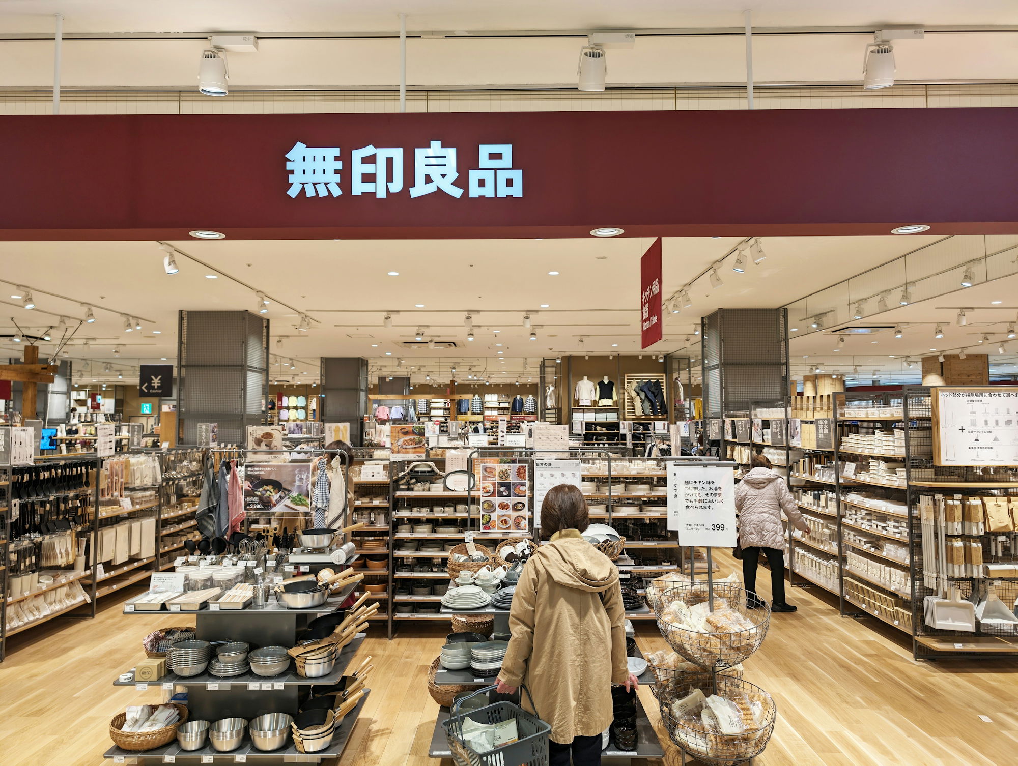 a woman standing in front of a store filled with items